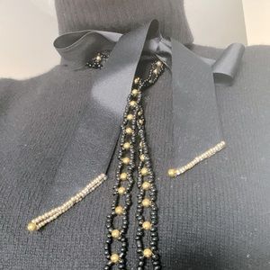 Decoration on the neck and clothes made of plastic beads on a ribbon.